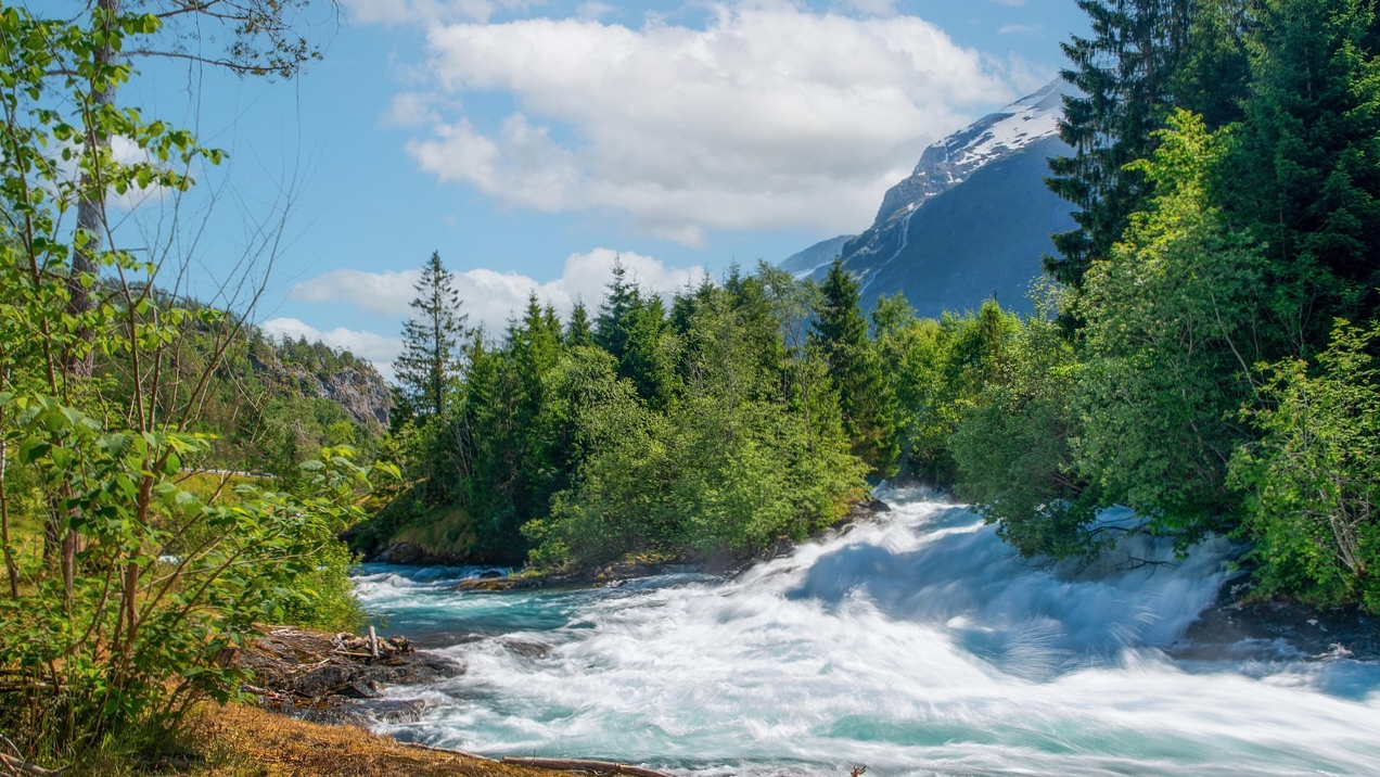 नॉर्वे के पहाड़ों के पीछे चमकता सूरज और रात का नजारा